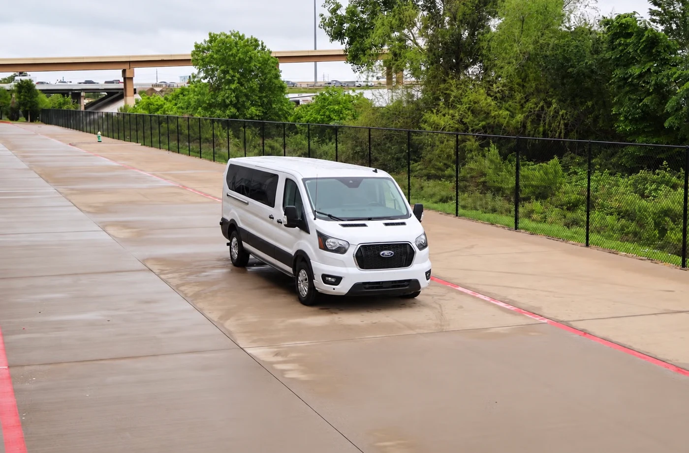 White Ford passenger van on a paved drive